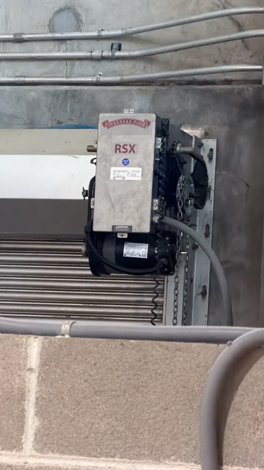Overhead Door RSX jackshaft operator with chain hoist mounted on a concrete wall