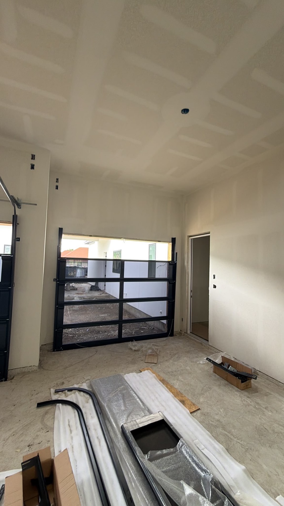 Black framed glass garage door installed in a finished garage bay