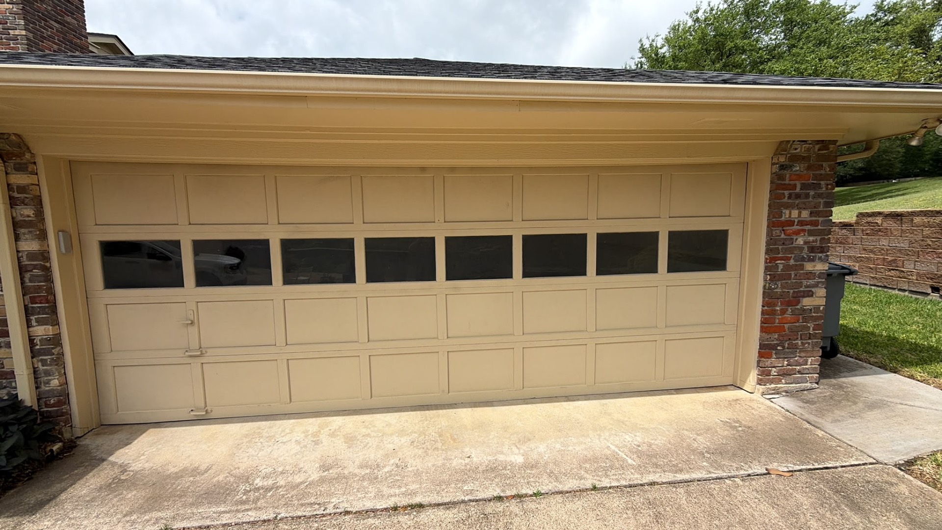 Carriage style garage door with window row on a brick home
