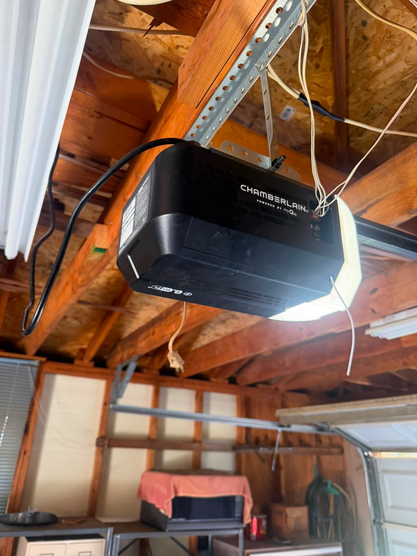 Chamberlain myQ WiFi garage door opener mounted to garage ceiling framing