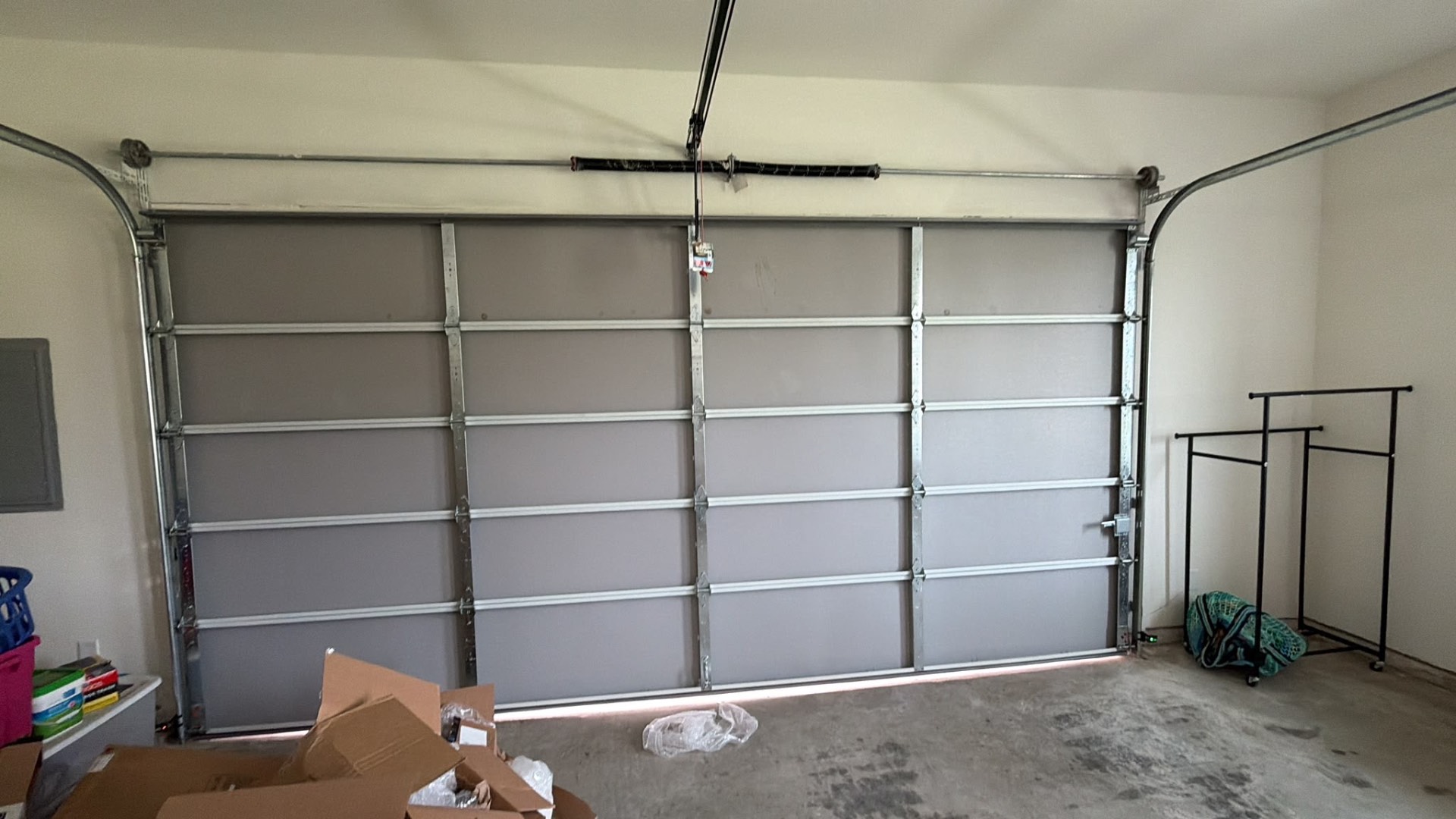 Interior view of a new flush gray garage door with fresh tracks and torsion spring